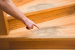 Man's hand pointing to the old scratched wooden stairs' step in the house. Problems and solutions concept.