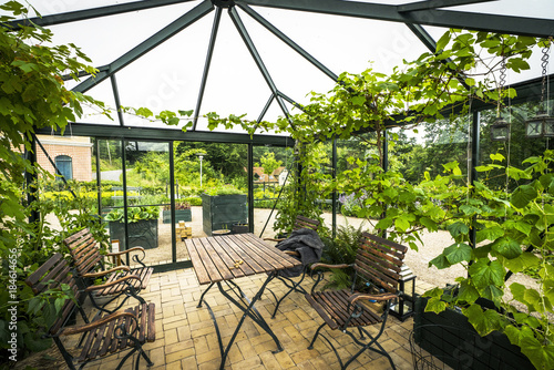 Fotografía Terrace in a glass house with wooden garden furniture