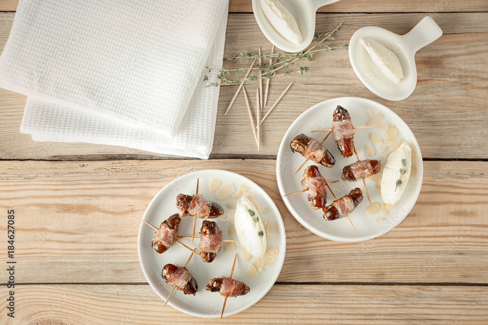 Plates with bacon wrapped dates on table