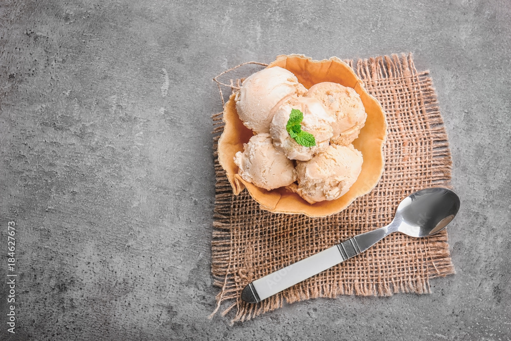 Delicious ice cream in waffle bowl on grey background