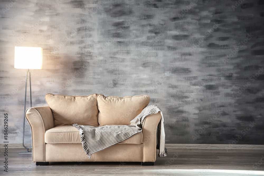 Comfortable sofa and floor lamp in room
