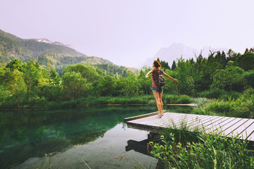 Wall Mural - Young woman with raised arms up on the nature background.