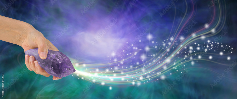 Massive Amethyst with beautiful energy - female hand holding large terminated amethyst quartz wand  shooting out sparkles across a purple and jade energy background with copy space
 - obrazy, fototapety, plakaty 