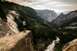 A man standing on a rock observes the landscape from the top of a waterfall in Yosemite, California (USA)