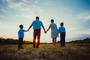 Wall Mural - Happy family on the background of the sunset