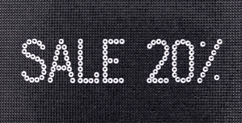 Sticker - Word SALE is made rhinestones crystal color on a black canvas background.