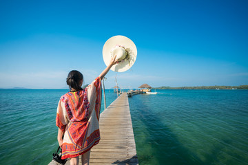 Wall Mural - Asian lady walk in wooded bridge to harbor in Koh Mak, Mak and Kood island is travel place in Thailand, This image can use for Holiday, summer, beach, sea and travel concept
