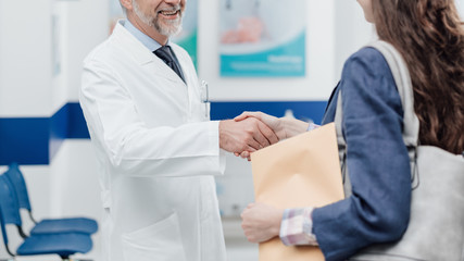 Wall Mural - Doctor welcoming a patient at the clinic