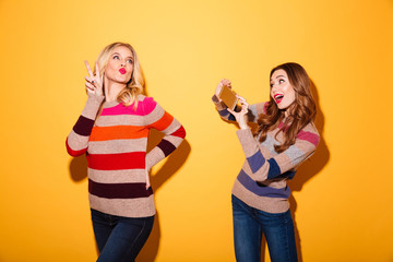 Canvas Print - Happy girl taking a photo of her girlfriend