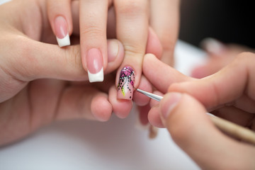 Closeup shot man making manicure to woman in beauty salon