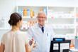 © Syda Productions - apothecary taking customer credit card at pharmacy