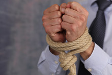 Businessman With A Rope Tied Hands. Rules, Law Prevents, Restrictions And Limits In Work.