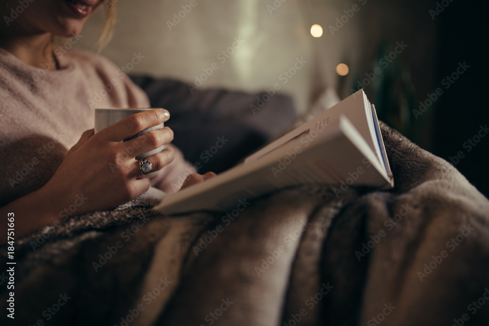 Female reading book on bed at night - obrazy, fototapety, plakaty 