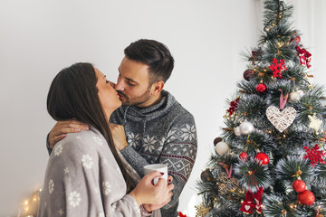 Wall Mural - Kissing next to Christmas tree