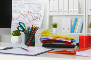 Office table with blank notepad and laptop