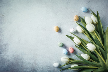 Wall Mural - Spring and Easter background. White tulips with colorful quail eggs. Holiday concept with copy space.