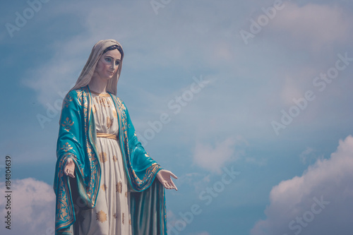 Fotomural The Blessed Virgin Mary statue standing in front of The Cathedral of the Immaculate Conception at The Roman Catholic Diocese with blue sky in the background at Chanthaburi Province, Thailand