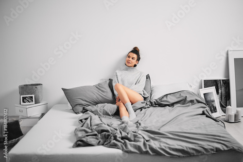 Girl sitting on bed in the morning фотография Stock.