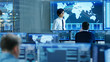 © Gorodenkoff - In the System Control Room Manager Holds a Briefing for His Staff Members. They're Work in Data Center and are Surrounded by Multiple Screens Showing Maps, Logistics Data.