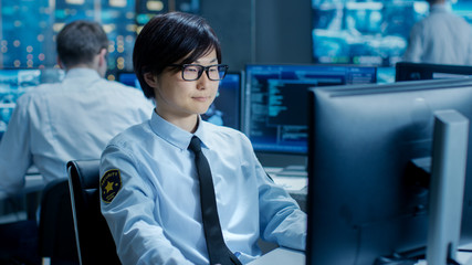 Leinwandbilder - In the Security Command Center Officer at His Workstation Monitors Multiple Screens for Unlawful Infiltration. They're Guarding Important International Logistics Facility.