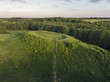 Aerial view over beautiful lake Uosis with a historical mound and small island in it near Veisiejai village, Lithuania. During sunny summer evening.