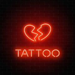 Wall Mural - Tattoo parlor glowing neon signboard with emblem. Broken heart glowing logo on a brick wall background.