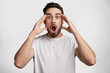 © wayhome.studio  - Horizontal shot of stupefied stunned shocked bearded young male keeps mouth widely opened, being surprised and very emotional as forgets about important meeting, expresses great surprisment.