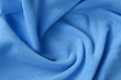 The blanket of furry blue fleece fabric. A background of light blue soft plush fleece material with a lot of relief folds
