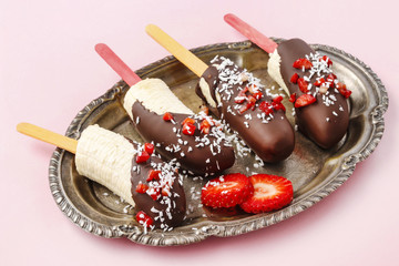 Canvas Print - Chocolate dipped bananas with strawberries and coconut flakes.