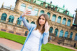 © luchschenF - Girl makes photos shots of european city Dresden and selfie of background old German town