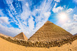 Great Pyramids in Giza, Egypt, with blue sky and bright sun
