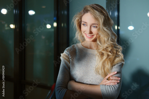 Beautiful Girl With Long Curly Blonde Hair Posing With Crossed