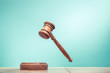 © BrAt82 - Retro auction or judge wooden gavel conceptual composition front mint green background. Symbols of justice. Vintage old style filtered photo