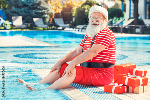 Foto Santa Claus near the pool holiday vacation concept