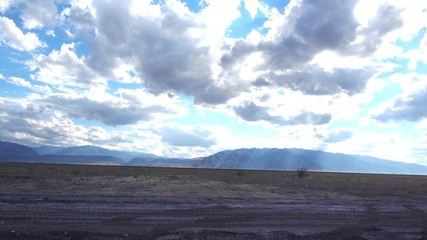 Wall Mural - The car rides on a dry steppe in the distance a ridge of high mountains