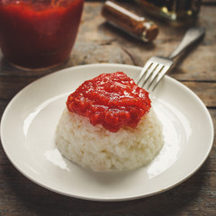 boiled round rice on a white plate, on a wooden surface