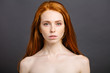 Beauty fashion portrait of nude redhead woman with perfect skin. attractive sexy girl with shiny hair on grey background