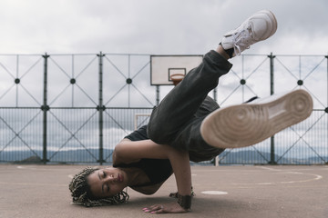 Wall Mural - Beautiful woman dancing hip hop in basketball court.