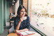 © makistock - Portrait of happy young business woman with mug in hands drinking coffee in the morning at restaurant