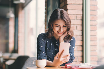 Beautiful cute asian young businesswoman in the cafe, taking selfie photo by mobile phone