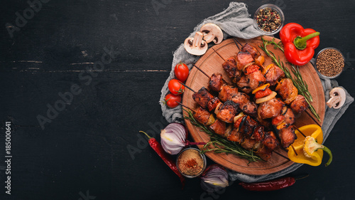 Fotomural Shish kebab on skewers with onions. On the black wooden table.