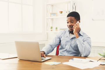 Wall Mural - Young black businessman talking on mobile phone