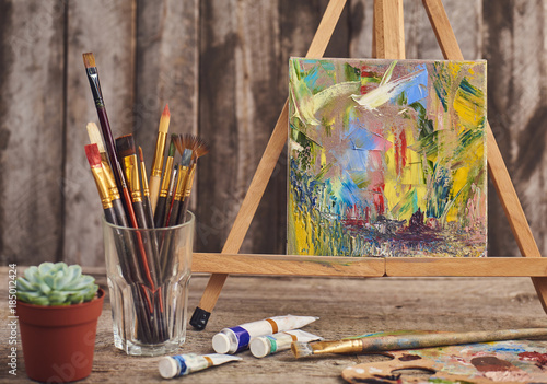 Artistic Paintbrushes Canvas With Abstraction On Easel Tubes Of