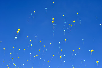 Wall Mural - blue and yellow  balloons in the city festival on blue sky background 