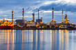 © Southtownboy Studio - Oil refinery plant at twilight with after rain sky background.