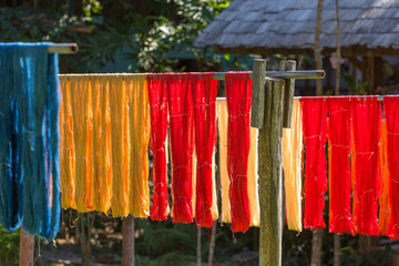 Colorful fabric hanging to dry after traditional dye processshot in Luang Prabang, Laos