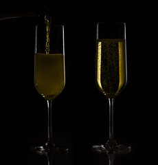 Two festive champagne glasses on black background