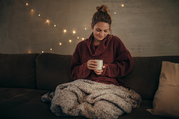 Wall Mural - Relaxed woman drinking coffee in winter at home