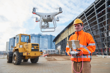 Wall Mural - drone operated by construction worker on building site