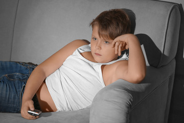 Wall Mural - Overweight boy watching TV at home